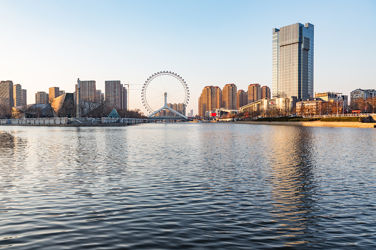 Tianjin waterfront downtown skyline with big ferris wheel over Hai river,China.